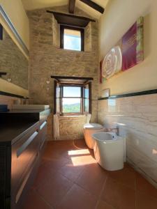 a bathroom with a toilet and a sink and a window at Prana Hill in Cupramontana +20 photos