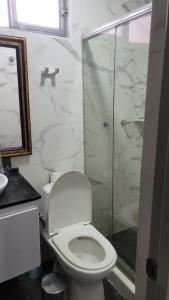 a bathroom with a toilet and a glass shower at BED & Breakfast in Bogotá