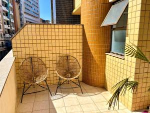 two chairs sitting on a balcony of a building at No centro da cidade 750m da universidade in Viçosa