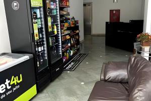 a store with a couch in front of a refrigerator at No centro da cidade 750m da universidade in Viçosa