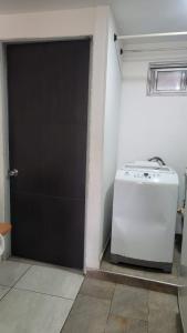 a garage with a washer and a door in a room at BED & Breakfast in Bogotá