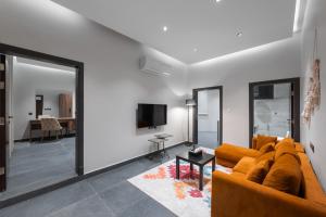 a living room with a couch and a tv at الاورفلي للوحدات السكنية in Sulţānah
