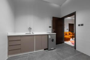 a kitchen with a sink and an orange couch at الاورفلي للوحدات السكنية in Sulţānah