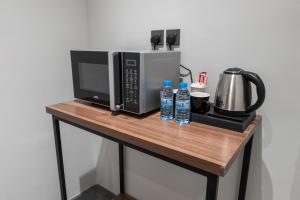 a table with a microwave and water bottles on it at الاورفلي للوحدات السكنية in Sulţānah