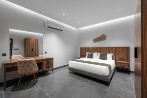 a bedroom with a bed and a desk and a chair at الاورفلي للوحدات السكنية in Sulţānah +76 photos