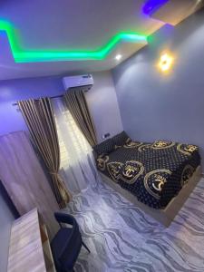 a small room with a bed and a green light at Asika Luxe Living in Ayobo
