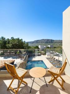 a patio with chairs and a table and a pool at Aethrion Villa Lindos in Lindos
