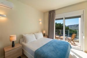 a bedroom with a bed and a large window at Aethrion Villa Lindos in Lindos +8 photos