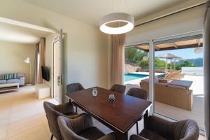 a dining room with a table and chairs and a pool at Aethrion Villa Lindos in Lindos