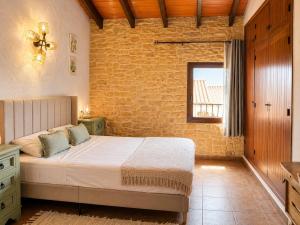 a bedroom with a bed and a brick wall at La Rustiqueta Javea terraza BBQ casco antiguo in Jávea