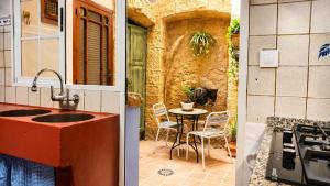 a kitchen with a sink and a table with chairs at La Rustiqueta Javea terraza BBQ casco antiguo in Jávea