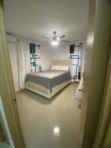 a bedroom with a bed in a room with windows at Estilo tropical 1 in La Romana