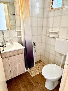 a bathroom with a toilet and a sink and a mirror at Xristinas Rooms in Lentas