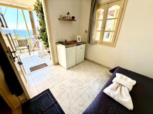 a room with a kitchen with a view of the ocean at Xristinas Rooms in Lentas +21 photos