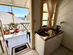 a kitchen with a sink and a view of a balcony at Xristinas Rooms in Lentas
