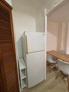 a white refrigerator in a kitchen with a table at L'Escale Auffan - Mourillon in Toulon