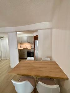 a kitchen with a wooden table and white chairs at L'Escale Auffan - Mourillon in Toulon