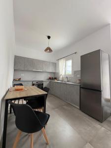 a kitchen with a table and a stainless steel refrigerator at NAXIAN OLIVE House in Glinado Naxos