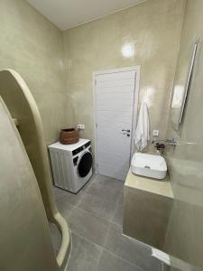 a bathroom with a toilet and a sink and a door at NAXIAN OLIVE House in Glinado Naxos +14 photos