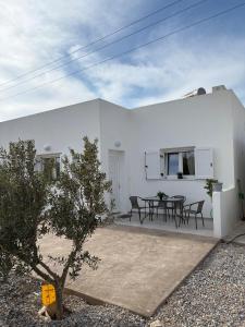 a white house with a table and chairs at NAXIAN OLIVE House in Glinado Naxos