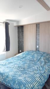 a bedroom with a bed with a blue comforter at Alloro-dog in Hem