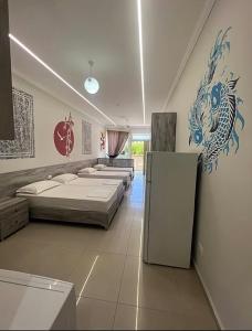 a room with four beds and a refrigerator in it at Helix Apartments in Fier
