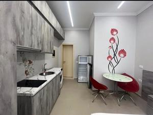 a kitchen with a table and red chairs in it at Helix Apartments in Fier