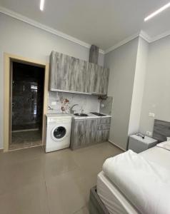 a kitchen with a stove and a washing machine at Helix Apartments in Fier