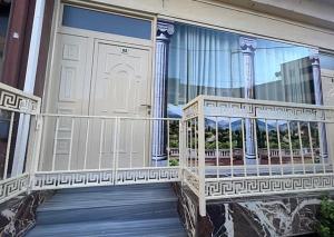 a balcony of a house with a door and columns at Helix Apartments in Fier