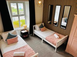 a room with two beds and a mirror at Trearddur View in Holyhead