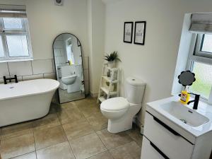 a bathroom with a tub and a toilet and a sink at Trearddur View in Holyhead +36 photos