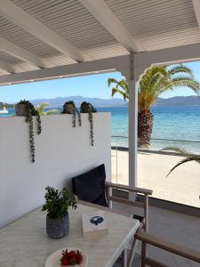 a patio with a table and a view of the beach at Ammos Beach in Glida