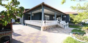 a house with a porch with a white railing at Jannas Home in Néa Karyá