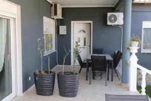 a dining room with blue walls and a table with plants at Jannas Home in Néa Karyá
