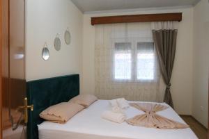 a bedroom with a bed with towels on it at Jannas Home in Néa Karyá
