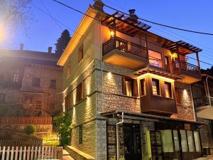 a brick house with a balcony on top of it at DG kores in Metsovo