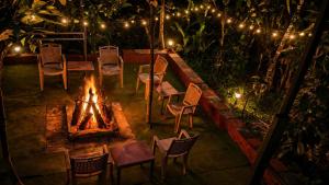a fire pit with chairs and a table and afire at CENTAURUS Coorg HOMESTAY in Madikeri +28 photos