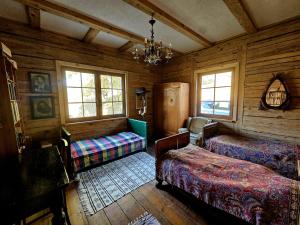 a bedroom with two beds and a chandelier at Gałęziówka, Doły Biskupie in Kunów