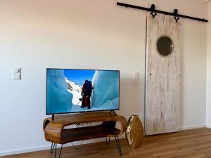 a flat screen tv sitting on a stand in a room at RheinStrand, wunderschöne, renovierte Wohnung in Dormagen