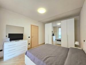 a bedroom with a bed and a tv on a dresser at Dimora del Centro in Acqui Terme
