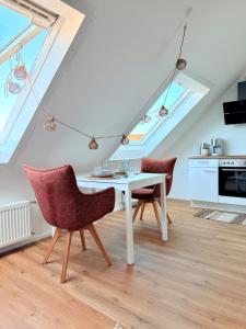a kitchen with a white table and two chairs at RheinStrand, wunderschöne, renovierte Wohnung in Dormagen +10 photos