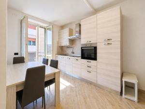 a kitchen with a wooden table and chairs and a dining room at Dimora del Centro in Acqui Terme