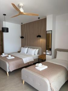 a bedroom with two beds and a ceiling fan at Ammos Beach in Glida