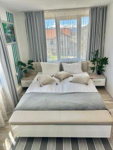 a large bed in a bedroom with windows at Bulgarane House in Govedartsi
