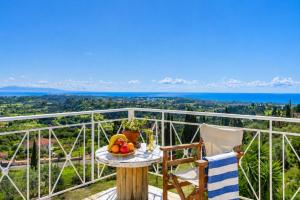 a table with a bowl of fruit on top of a balcony at Ionian Balcony Hotel Apartments in Khavdháta