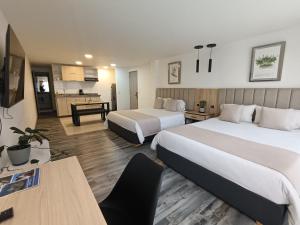 a hotel room with two beds and a kitchen at Hotel 86 Suites in Bogotá