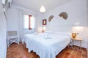 a bedroom with two beds with white sheets at Villa Binisol in Binibeca +15 photos