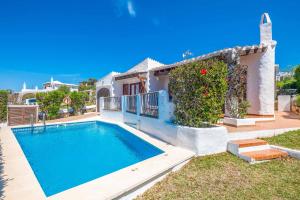 a villa with a swimming pool in front of a house at Villa Binisol in Binibeca