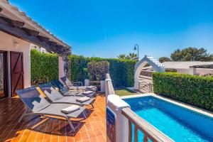 a group of chairs sitting next to a swimming pool at Villa Binisol in Binibeca