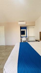 a large room with a bed and a tv at Hotel Plaza del Ángel in Huajuapan de León